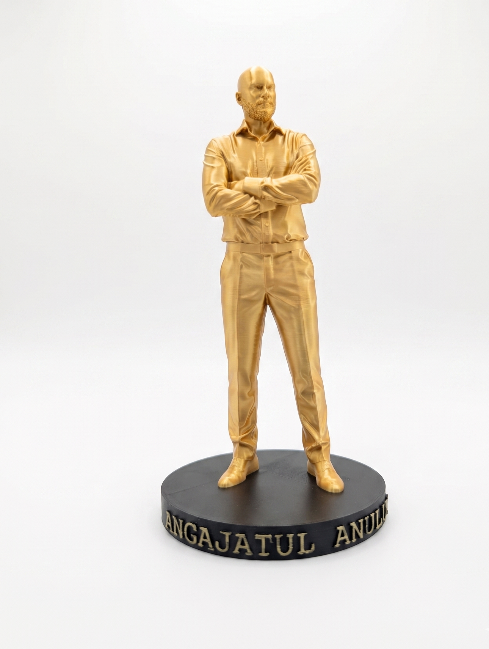 Statuetă auriu imprimată 3D a unui bărbat cu brațele încrucișate pe un soclu negru cu textul 'ANGAJATUL ANULUI'.